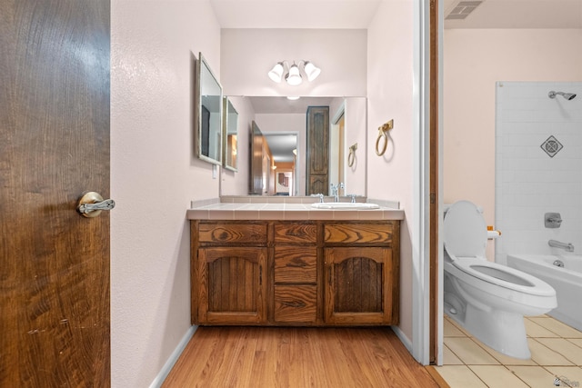 1228 S 40th Dr, Yuma, AZ 85364 - bathroom with vanity, toilet, shower / tub combination, wood finished floors, and baseboards
