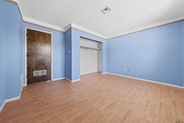 1228 S 40th Dr, Yuma, AZ 85364 - unfurnished bedroom with light wood finished floors, a textured ceiling, and baseboards