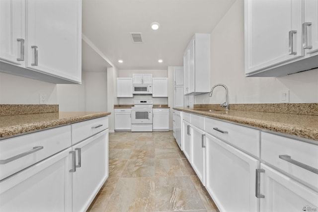 321 S 23rd Ave, Yuma, AZ 85364 - kitchen featuring visible vents, a sink, white cabinets, and white appliances