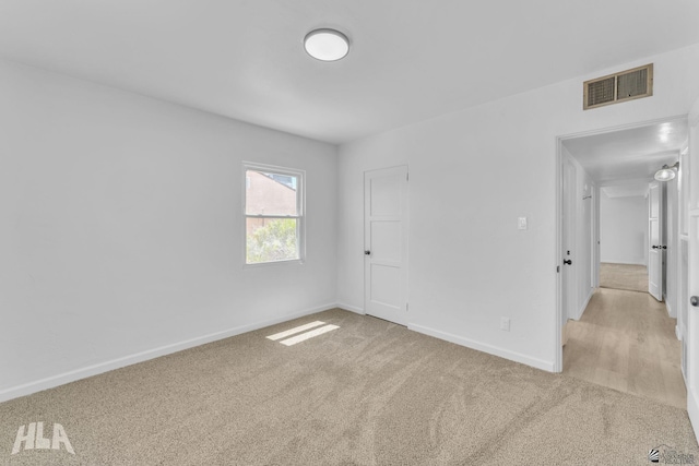 unfurnished bedroom with baseboards, visible vents, and light carpet