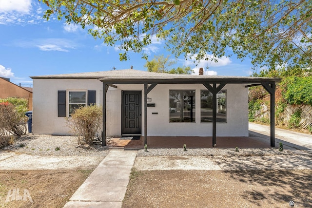 bungalow-style home with stucco siding