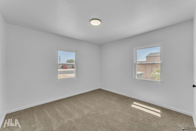 carpeted empty room with baseboards