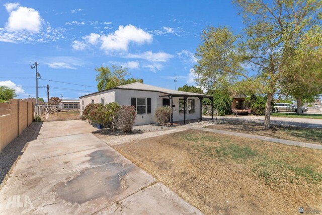 view of front of property featuring fence, stucco siding, and driveway