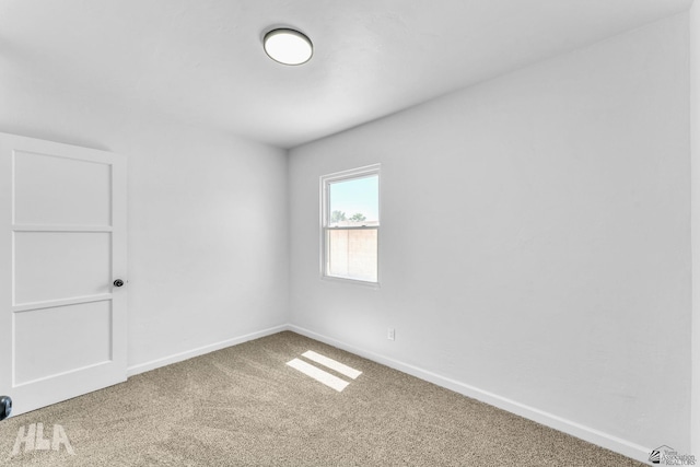 carpeted spare room featuring baseboards