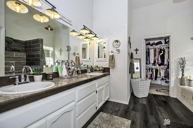 2877 W 13th Pl, Yuma, AZ 85365 - bathroom featuring wood finished floors, double vanity, a sink, and a towering ceiling
