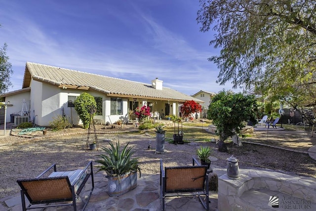 2877 W 13th Pl, Yuma, AZ 85365 - rear view of property featuring central air condition unit, stucco siding, a chimney, and a patio area