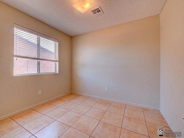 8576 E 38th St, Yuma, AZ 85365 - unfurnished room with a textured ceiling and light tile patterned floors