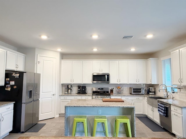 14650 E 42nd Pl, Yuma, AZ 85367 - kitchen featuring stainless steel appliances, backsplash, a sink, white cabinetry, and recessed lighting