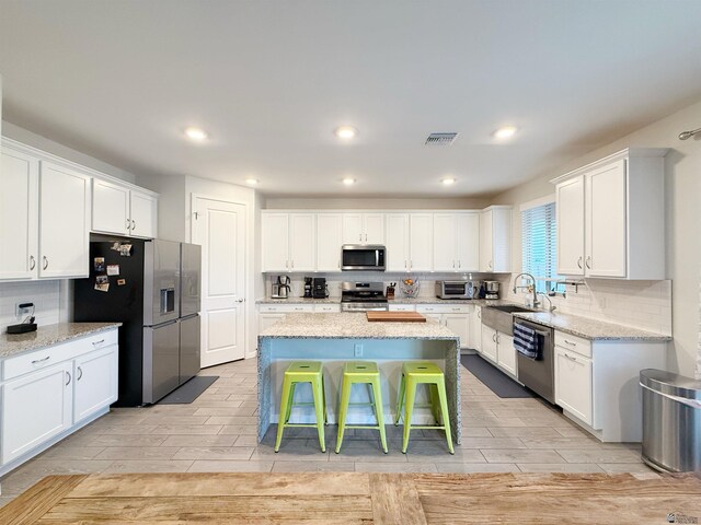 14650 E 42nd Pl, Yuma, AZ 85367 - kitchen featuring stainless steel appliances, a kitchen island, wood tiled floors, white cabinetry, and recessed lighting