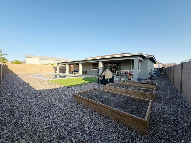 14650 E 42nd Pl, Yuma, AZ 85367 - back of property featuring a fenced backyard, a patio area, a garden, stucco siding, and central AC unit