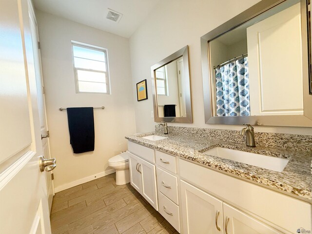 14650 E 42nd Pl, Yuma, AZ 85367 - bathroom with double vanity, baseboards, wood finished floors, and toilet
