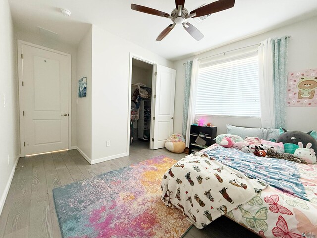 14650 E 42nd Pl, Yuma, AZ 85367 - bedroom with wood finished floors, baseboards, a walk in closet, and a ceiling fan