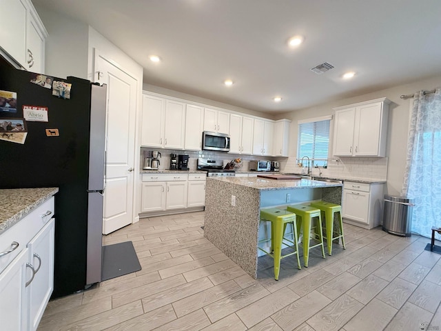 14650 E 42nd Pl, Yuma, AZ 85367 - kitchen featuring stainless steel appliances, light wood finished floors, white cabinetry, tasteful backsplash, and recessed lighting