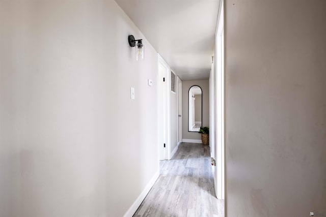 hall featuring light wood finished floors and baseboards