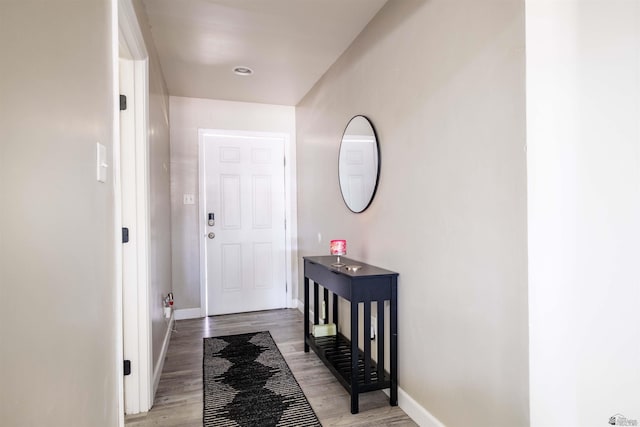 doorway to outside featuring baseboards and light wood-type flooring