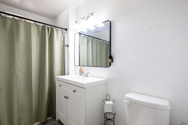 full bathroom with toilet, vanity, and wood finished floors