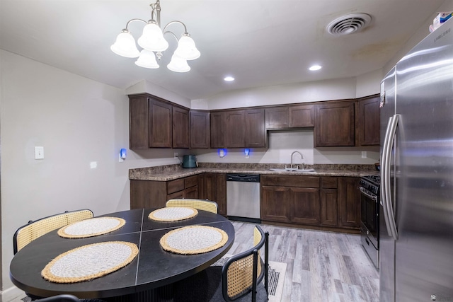 kitchen with appliances with stainless steel finishes, a sink, a chandelier, light wood-type flooring, and dark brown cabinetry