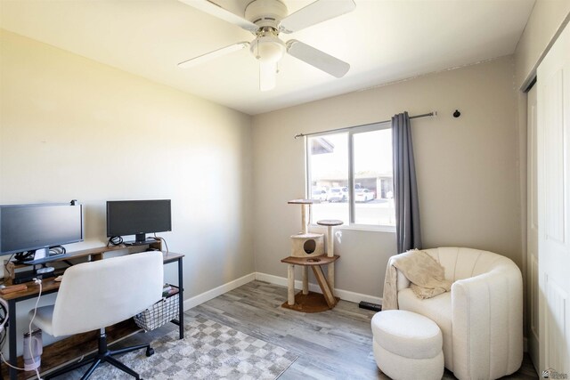 home office with light wood finished floors, ceiling fan, and baseboards