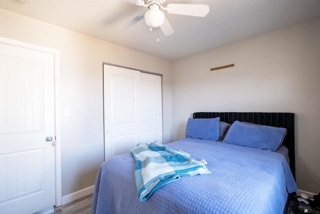 bedroom featuring wood finished floors, a closet, ceiling fan, and baseboards