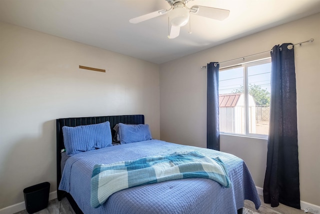 bedroom with baseboards, ceiling fan, and wood finished floors
