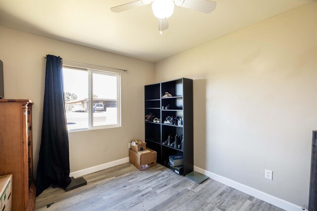 unfurnished room featuring a ceiling fan, light wood-style floors, and baseboards