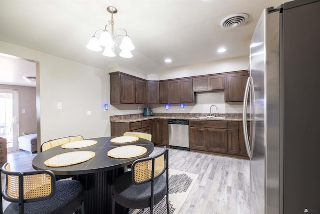 kitchen featuring appliances with stainless steel finishes, light wood-style flooring, a chandelier, a sink, and dark brown cabinetry