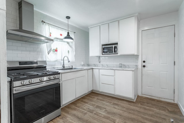3566 W 5th St, Yuma, AZ 85364 - kitchen with stainless steel appliances, wall chimney exhaust hood, a sink, and decorative backsplash