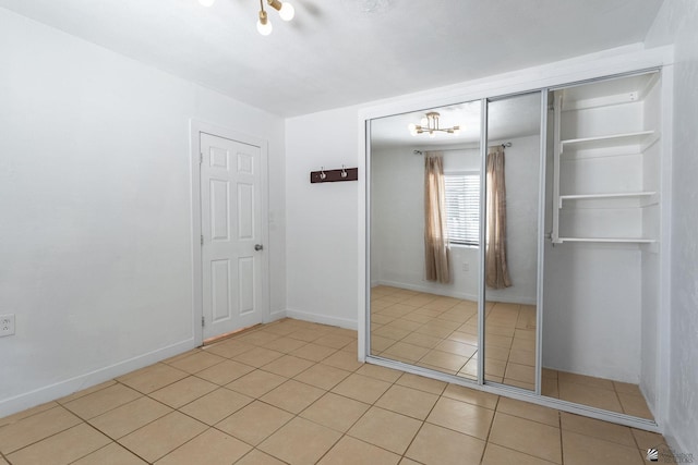 3566 W 5th St, Yuma, AZ 85364 - unfurnished bedroom with light tile patterned flooring, a closet, and baseboards