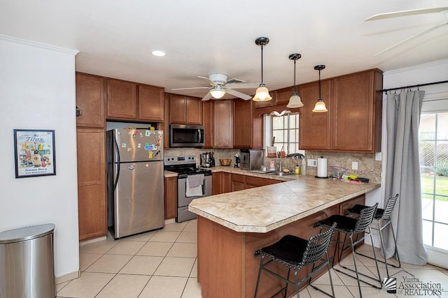 4539 W 17th St, Yuma, AZ 85364 - kitchen with stainless steel appliances, a ceiling fan, a sink, brown cabinets, and crown molding