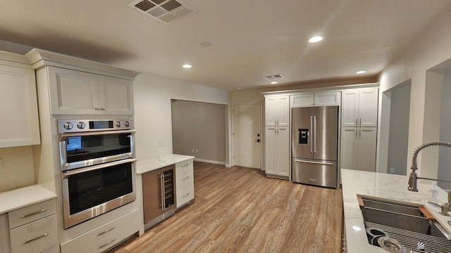 1350 S 6th Ave, Yuma, AZ 85364 - kitchen with stainless steel appliances, beverage cooler, light wood finished floors, recessed lighting, and light stone countertops