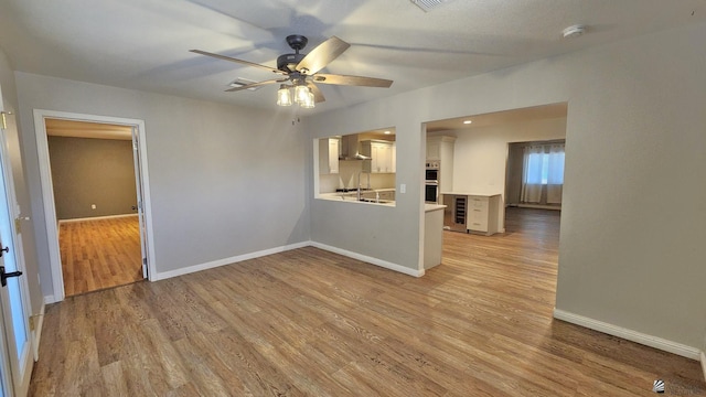 1350 S 6th Ave, Yuma, AZ 85364 - empty room with wine cooler, a ceiling fan, light wood-style flooring, and a smoke detector