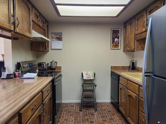 2045 S 14th Ave # 79, Yuma, AZ 85364 - kitchen featuring black appliances, under cabinet range hood, brick patterned floors, baseboards, and light countertops