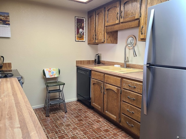 2045 S 14th Ave # 79, Yuma, AZ 85364 - kitchen with appliances with stainless steel finishes, a sink, baseboards, brick patterned flooring, and wood counters