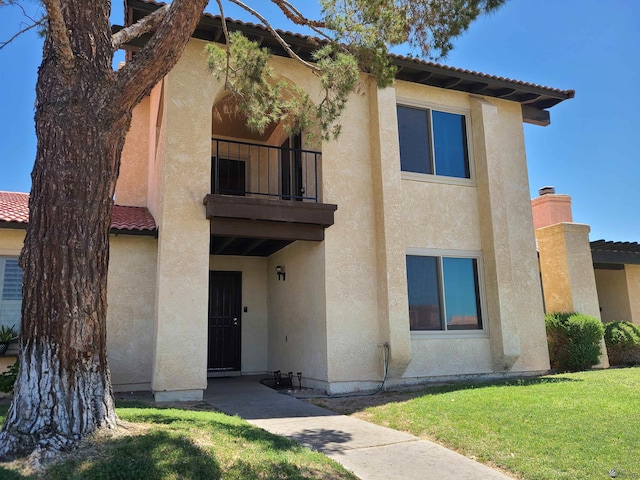 2045 S 14th Ave # 79, Yuma, AZ 85364 - view of front of home featuring stucco siding, a balcony, and a front lawn