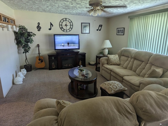 living room with ceiling fan, carpet, and a textured ceiling