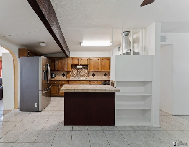 3186 S Elm St, Yuma, AZ 85364 - kitchen with stainless steel fridge with ice dispenser, light tile patterned floors, a peninsula, tasteful backsplash, and a textured ceiling