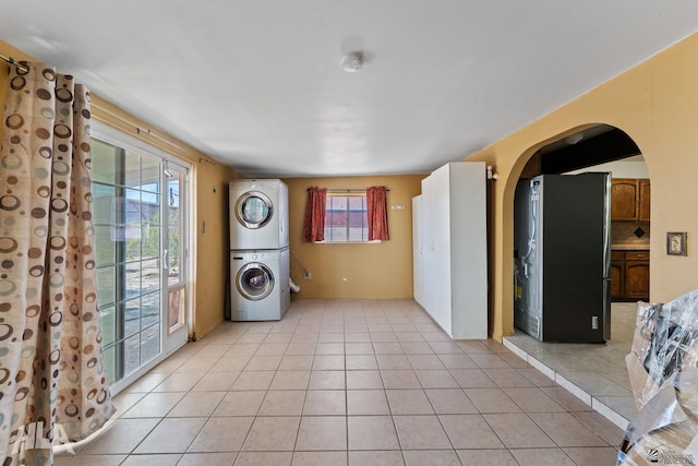 3186 S Elm St, Yuma, AZ 85364 - washroom featuring stacked washing machine and dryer, arched walkways, and light tile patterned flooring