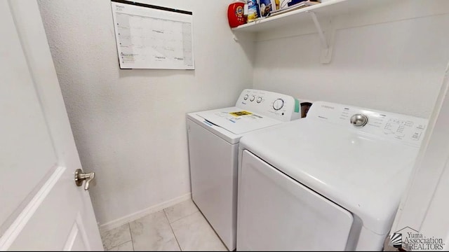 clothes washing area featuring independent washer and dryer, laundry area, and baseboards