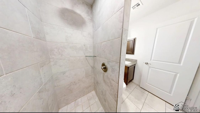 bathroom with vanity, tile patterned floors, a tile shower, and visible vents