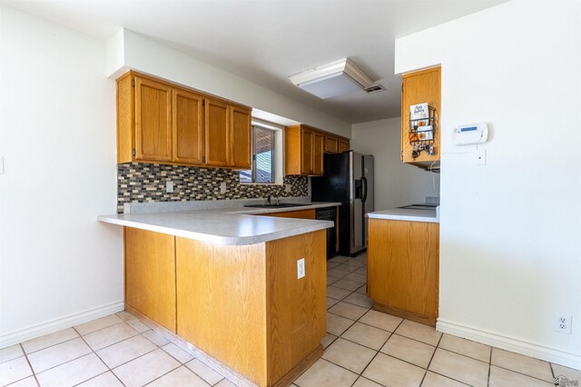 1986 S 47th Ave, Yuma, AZ 85364 - kitchen with a peninsula, a sink, light countertops, black appliances, and tasteful backsplash