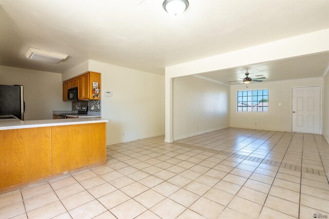 1986 S 47th Ave, Yuma, AZ 85364 - kitchen featuring appliances with stainless steel finishes, brown cabinets, light tile patterned floors, backsplash, and a ceiling fan