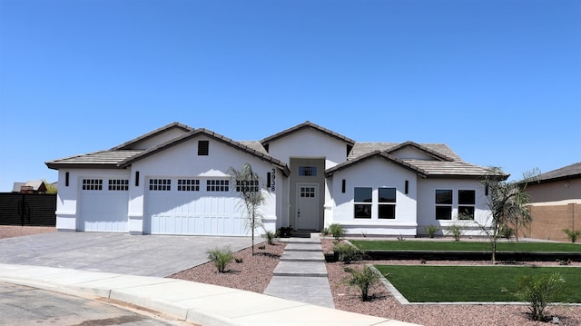 ranch-style home with fence, a tile roof, a garage, stucco siding, and driveway