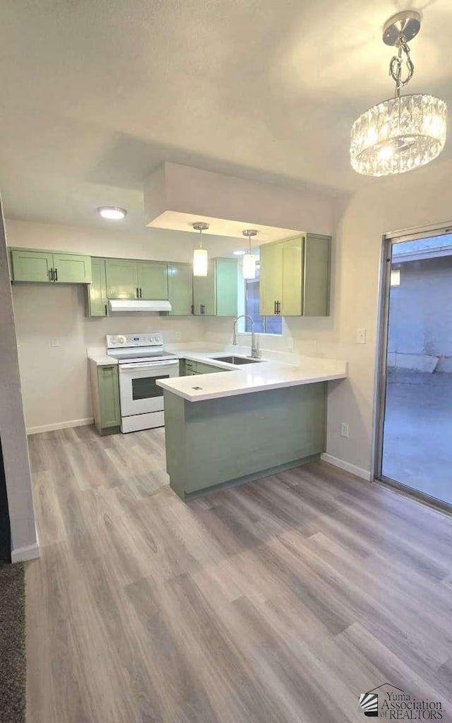 kitchen featuring a peninsula, green cabinetry, white range with electric stovetop, and baseboards