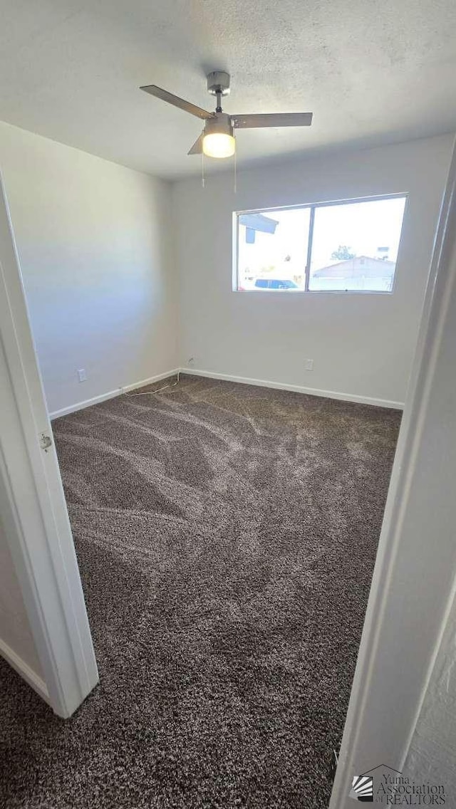 unfurnished room with baseboards, ceiling fan, and carpet