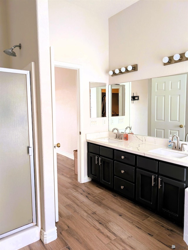 bathroom featuring a sink, a stall shower, and wood finished floors