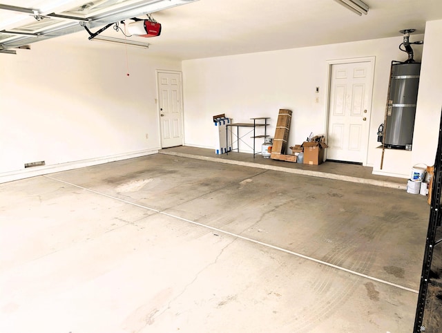 garage featuring strapped water heater and a garage door opener