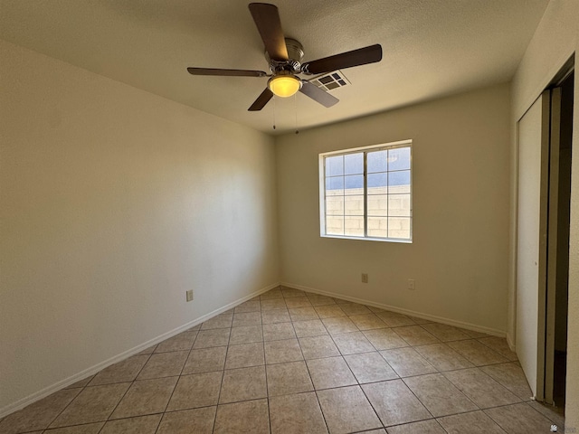 unfurnished bedroom featuring visible vents, a closet, light tile patterned flooring, baseboards, and ceiling fan