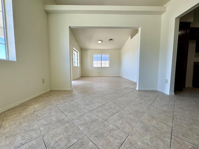 spare room featuring baseboards, visible vents, and light tile patterned floors