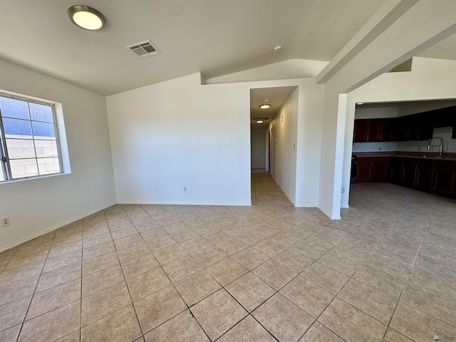 unfurnished room with a sink, light tile patterned floors, baseboards, and visible vents
