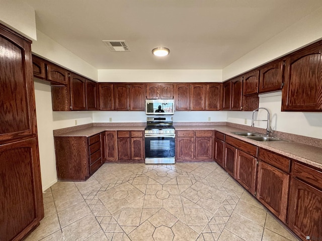 kitchen with visible vents, a sink, appliances with stainless steel finishes, and light tile patterned floors